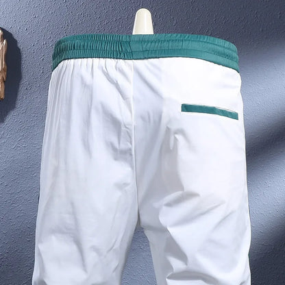Men's ice silk skinny sports pants in black or white with striped tapered leg and ankle-tied hem