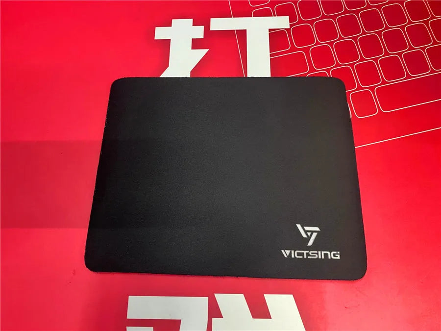 Large black thickened rubber mouse pad with a rough grain texture on a desk.