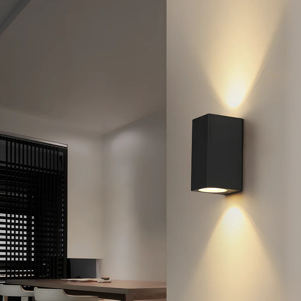 Black aluminium LED wall lamp with tempered glass shade mounted on white wall