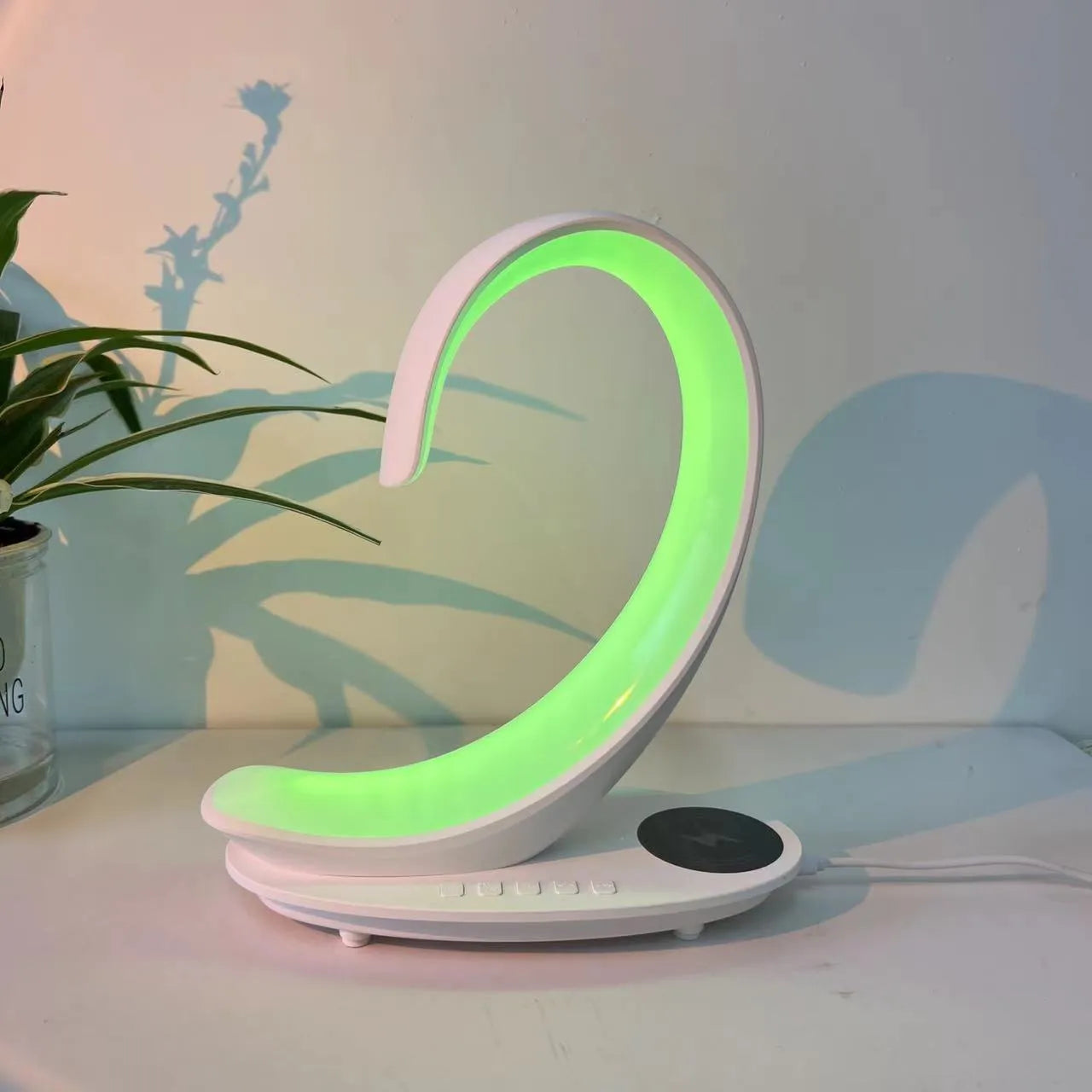 White swan-shaped desktop device with wireless charging surface, Bluetooth speaker, and colourful LED lighting effects