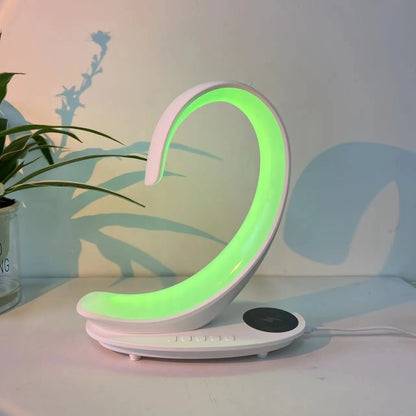 White swan-shaped desktop device with wireless charging surface, Bluetooth speaker, and colourful LED lighting effects