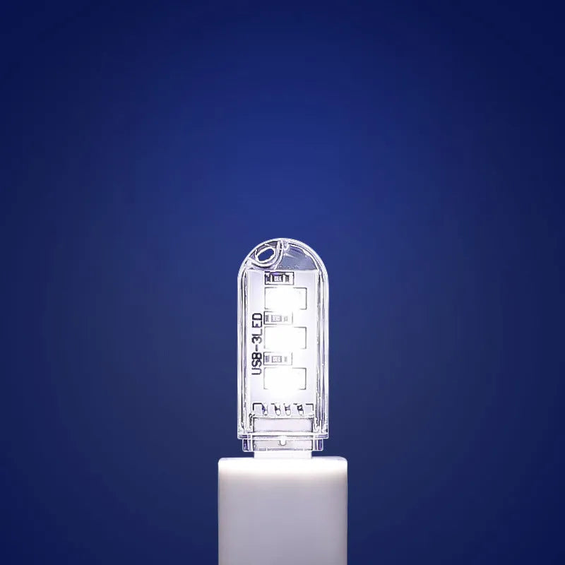 Small white USB LED baby night light showing warm and white light modes on a table.