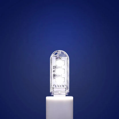 Small white USB LED baby night light showing warm and white light modes on a table.