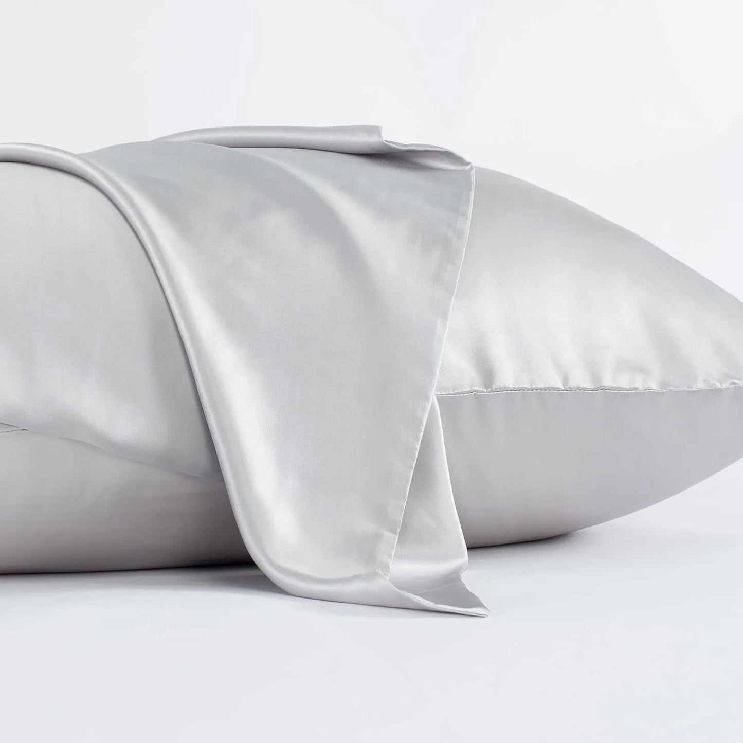 Dark grey silk pillowcase with envelope closure on a bed.