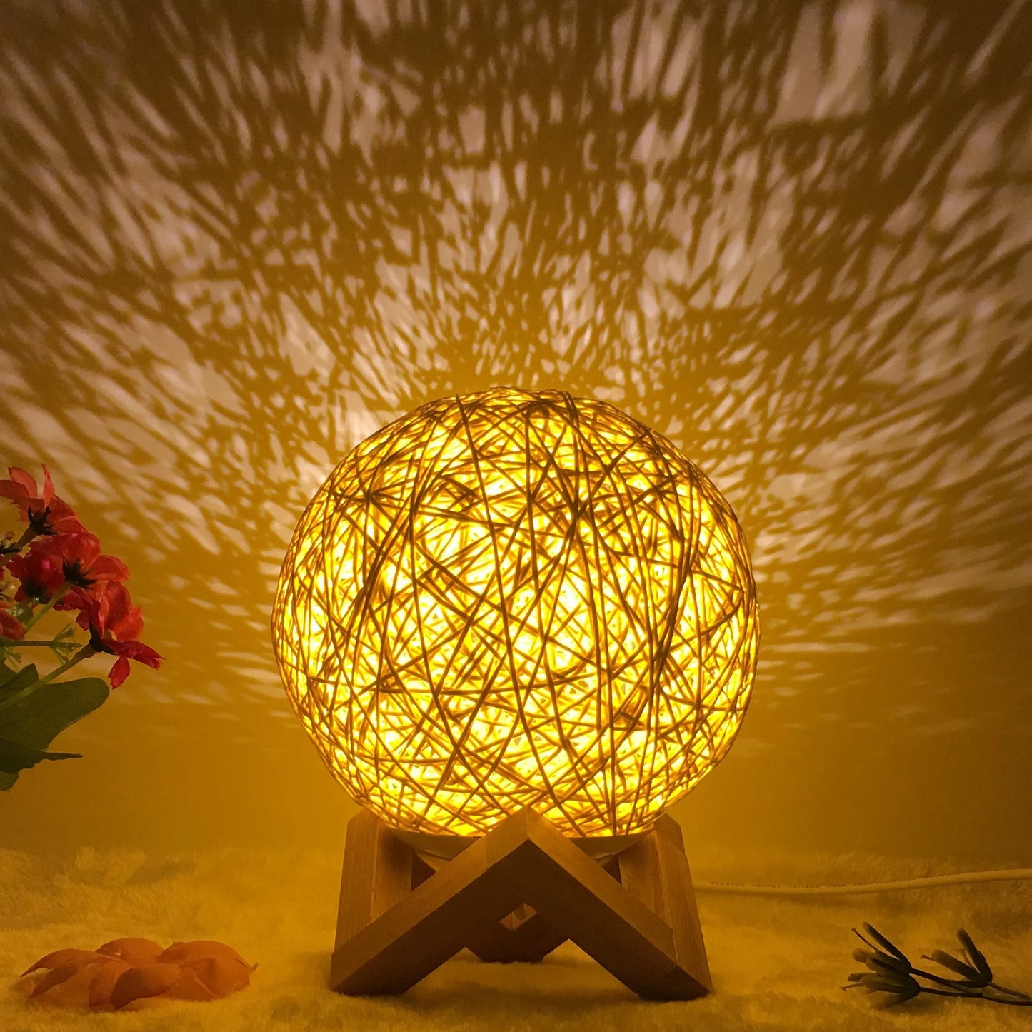 Spherical hand-knitted rattan table lamp with remote control on a wooden desk