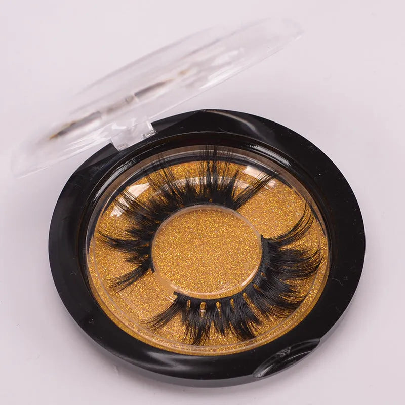 A pair of 5D mink false eyelashes with a hair storage cap and double-ended brush on a pink background.
