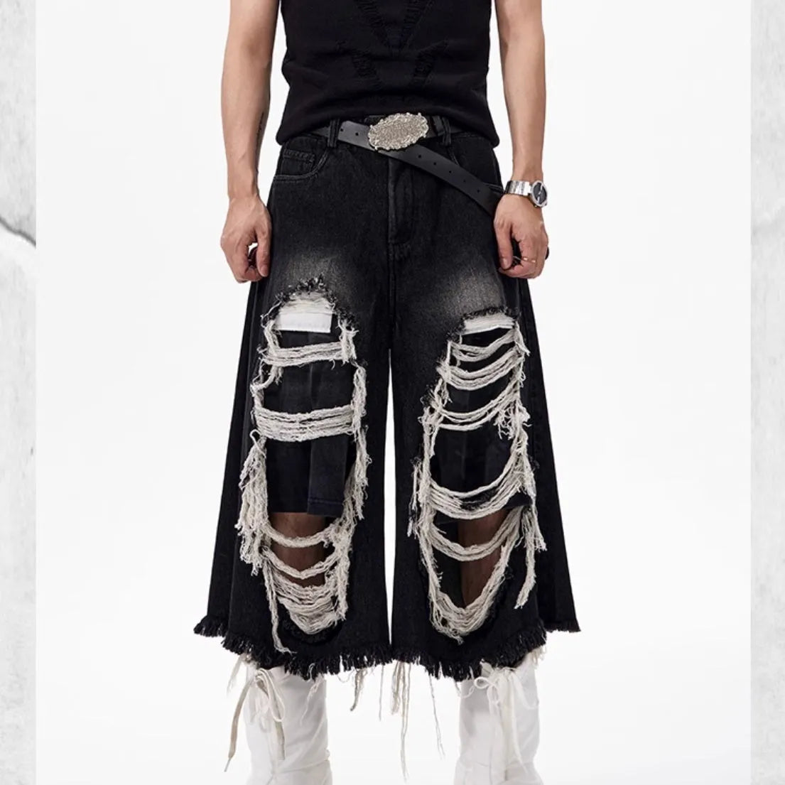 Black cropped wide-leg jeans with a mid-high waist, ripped patch detail, and a loose fit on a model.