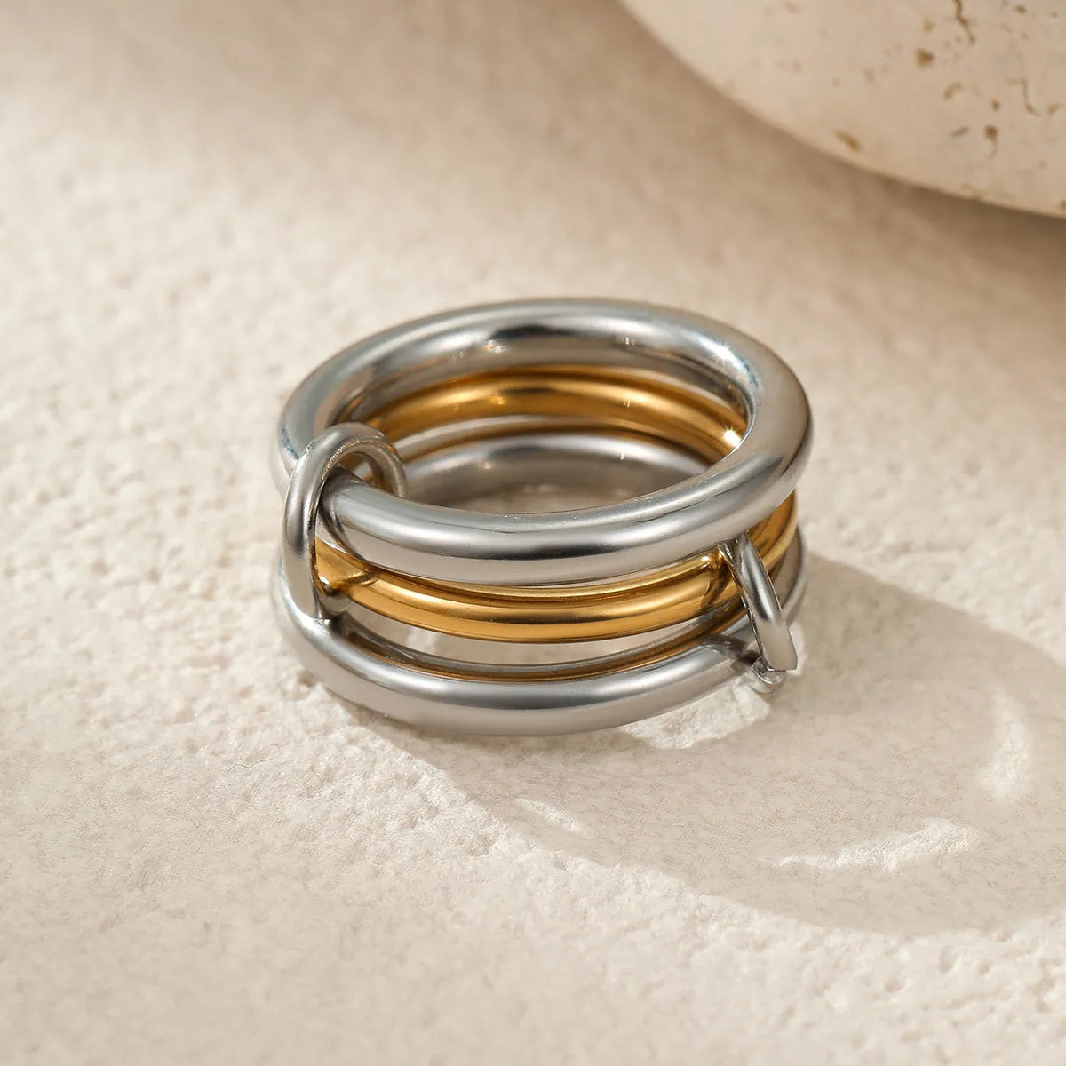 Stacked stainless steel rings with 18K gold plating in three colour variations, exaggerated hand jewellery designs