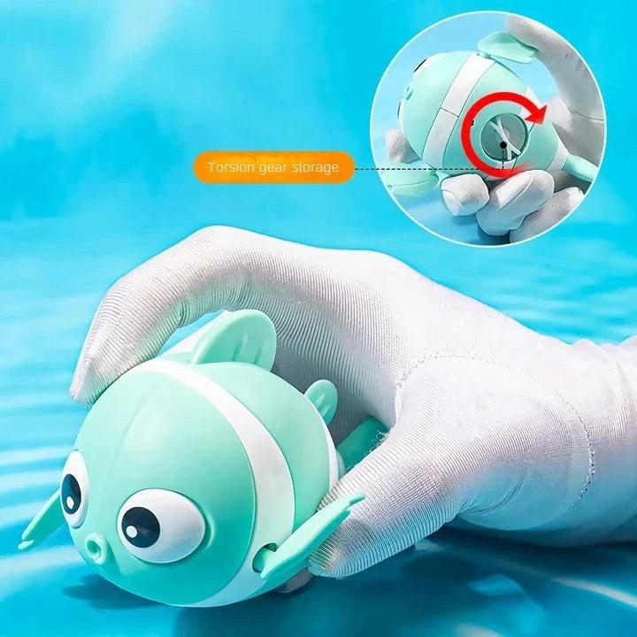 A pink wind-up swimming fish toy for babies and toddlers to play with during bath time.