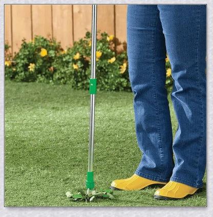 A standing weed puller tool with a long handle and 3-pronged head, designed to easily remove weeds from the root.