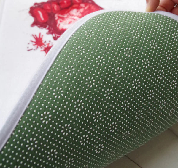 A rectangular bath mat with a vivid, lifelike blood-splatter design made of durable polyester material.