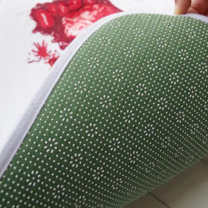 A rectangular bath mat with a vivid, lifelike blood-splatter design made of durable polyester material.