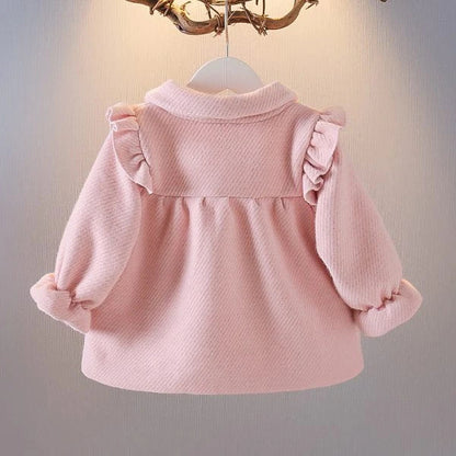A soft and cozy baby velvet coat in a classic round-neck design, available in a variety of colors to complement any outfit.