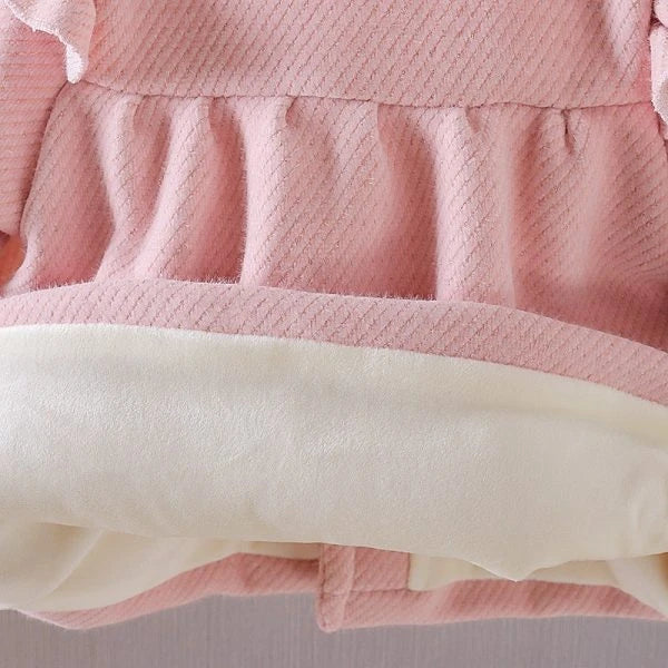 A soft and cozy baby velvet coat in a classic round-neck design, available in a variety of colors to complement any outfit.