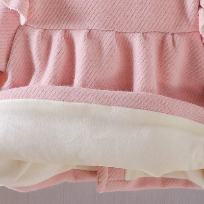 A soft and cozy baby velvet coat in a classic round-neck design, available in a variety of colors to complement any outfit.