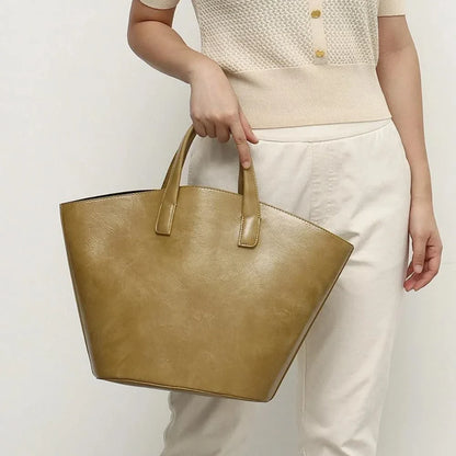Elegant vegan leather tote bag with a unique bucket shape, versatile carrying options, and a secure zip liner for all your daily essentials.