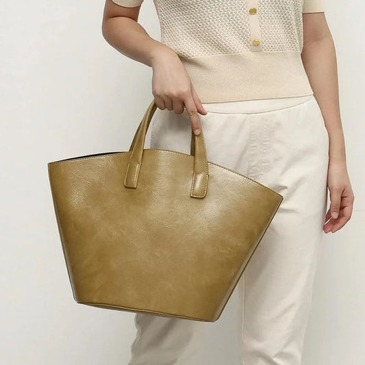 Elegant vegan leather tote bag with a unique bucket shape, versatile carrying options, and a secure zip liner for all your daily essentials.