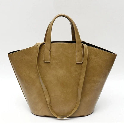 Elegant vegan leather tote bag with a unique bucket shape, versatile carrying options, and a secure zip liner for all your daily essentials.