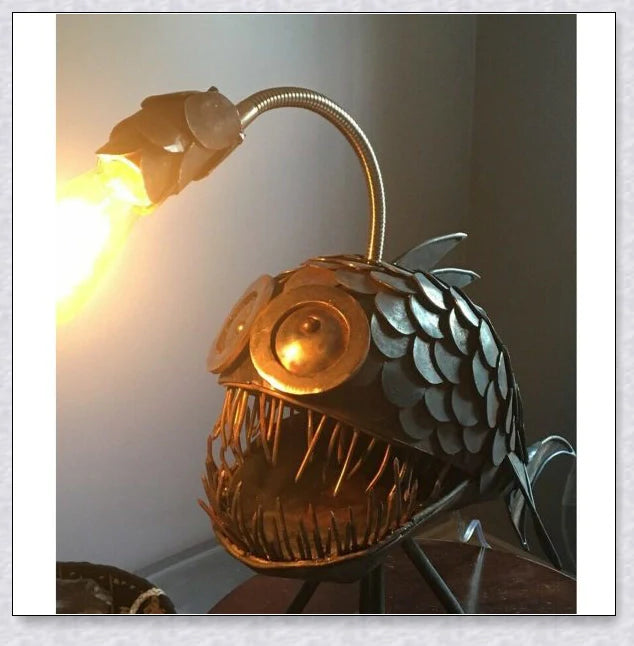 Steampunk angler fish-shaped lamp with rustic iron art tube design and warm, ambient lighting