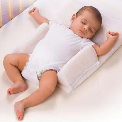 Newborn baby sleeping comfortably on the Baby Sleep Fixed Position & Anti Roll Pillow, with elevated head and air vent bumpers for optimal breathing and cooling.