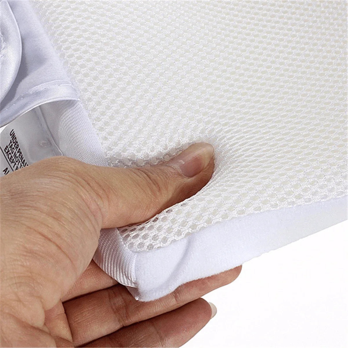 Newborn baby sleeping comfortably on the Baby Sleep Fixed Position & Anti Roll Pillow, with elevated head and air vent bumpers for optimal breathing and cooling.