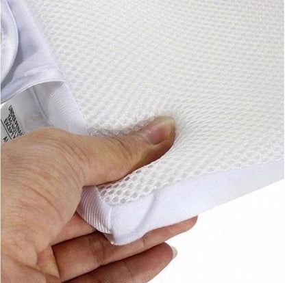 Newborn baby sleeping comfortably on the Baby Sleep Fixed Position & Anti Roll Pillow, with elevated head and air vent bumpers for optimal breathing and cooling.