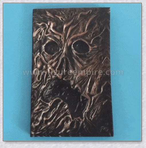 Necronomicon-inspired dark magic prop book with demonic face binding and barbed wire wrapping