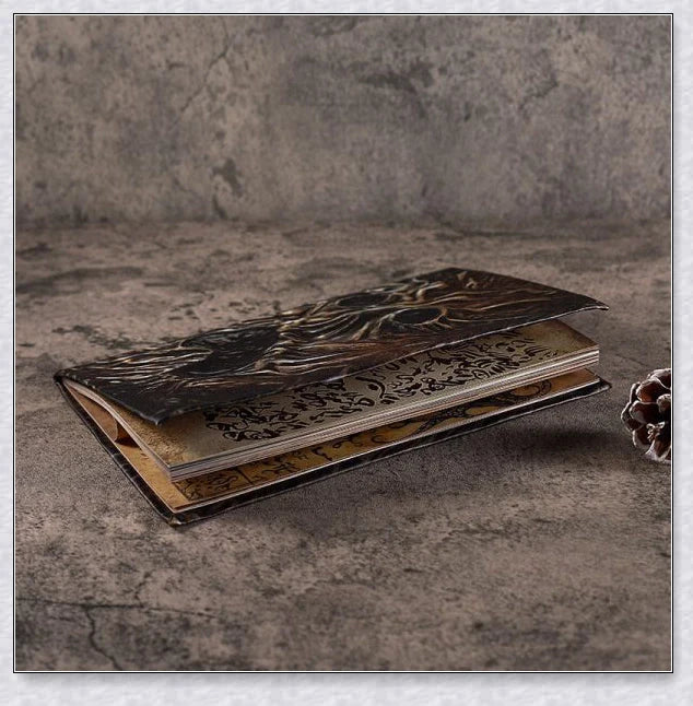 Necronomicon-inspired dark magic prop book with demonic face binding and barbed wire wrapping