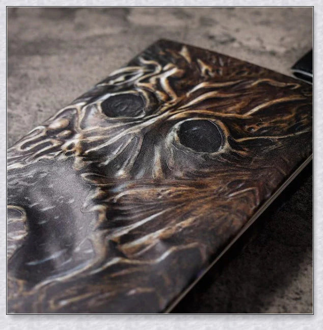 Necronomicon-inspired dark magic prop book with demonic face binding and barbed wire wrapping