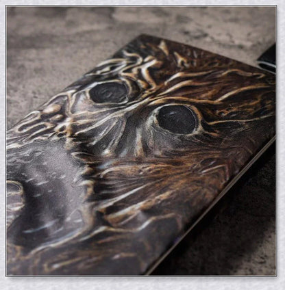 Necronomicon-inspired dark magic prop book with demonic face binding and barbed wire wrapping