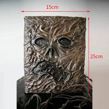 Necronomicon-inspired dark magic prop book with demonic face binding and barbed wire wrapping