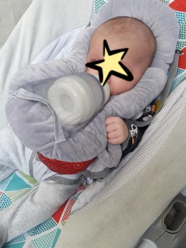 A soft, supportive pillow designed for hands-free baby feeding, featuring a secure bottle holder and premium, BPA-free materials.