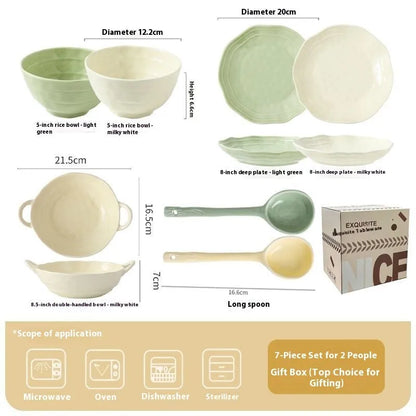 Boxed set of seven solid-colour ceramic plates and bowls on a table.