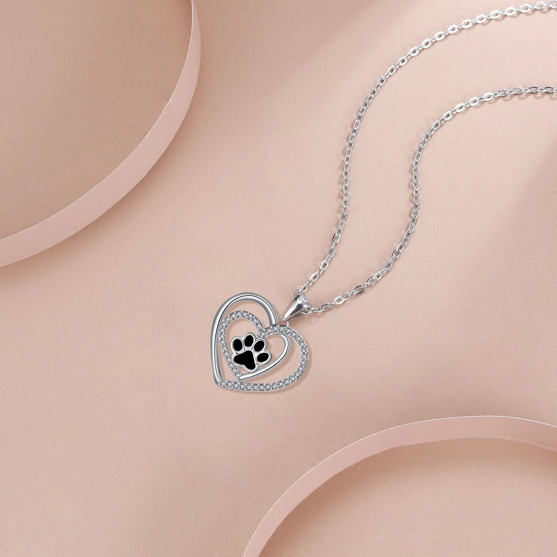 Copper heart pendant necklace with engraved dog paw print on a cross chain.