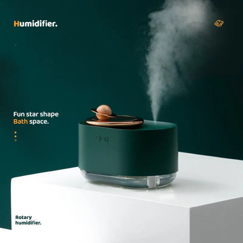 Rotating planet-shaped humidifier in green colour with USB cable and mist emitting from the top.