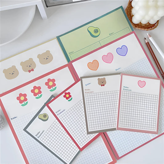 Cartoon sticky note pad in avocado or bear design, showing large and small size options next to a pen.