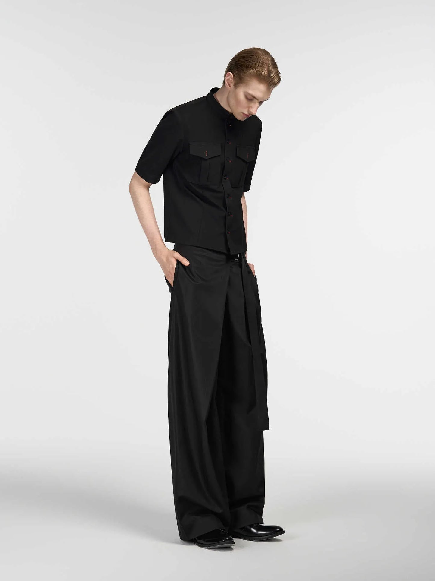 Black straight-leg trousers with a single front pleat and adjustable mid-waist on a hanger.