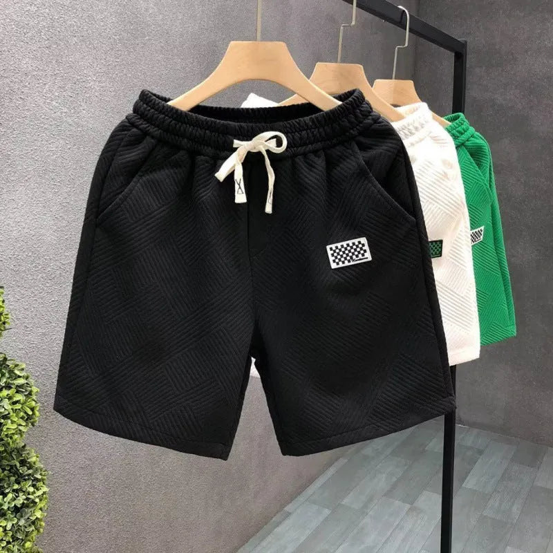 Man's solid colour casual sports shorts in micro-elastic polyester fabric on a beach background