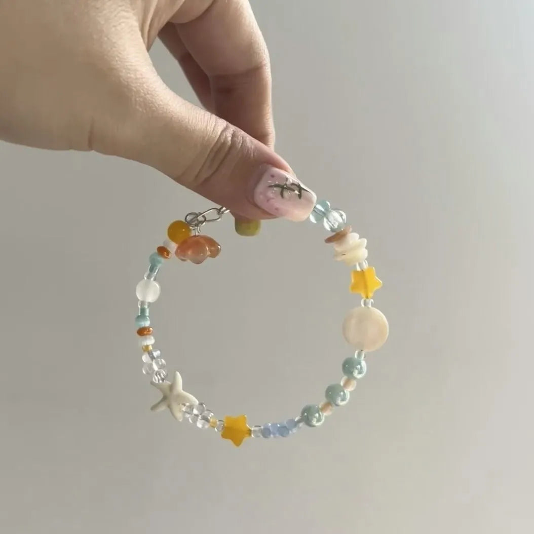 Women's orange mixed material bracelet with a diamond shape and round decorative elements.