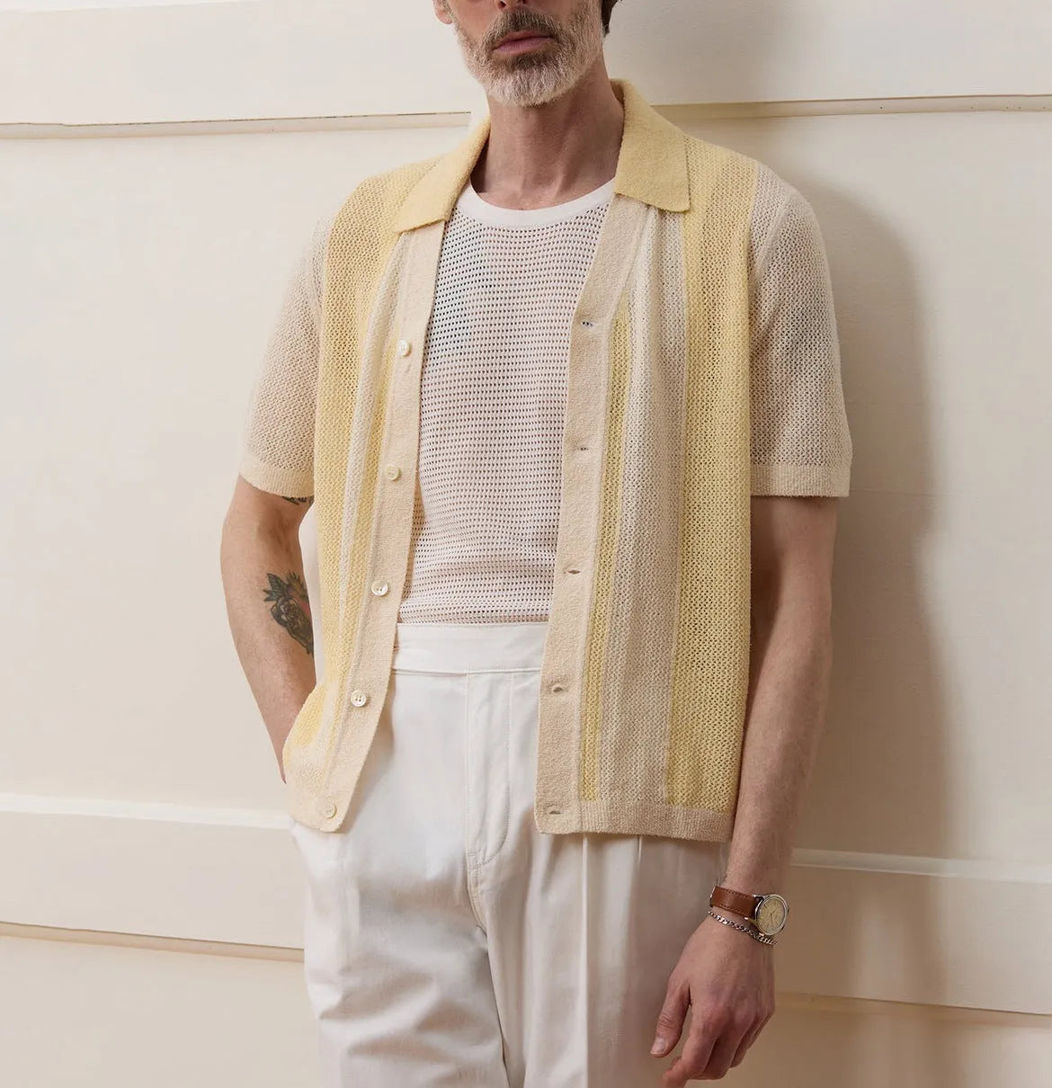 Yellow asymmetric short-sleeved polo shirt with hollow-out design on a hanger.