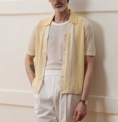 Yellow asymmetric short-sleeved polo shirt with hollow-out design on a hanger.