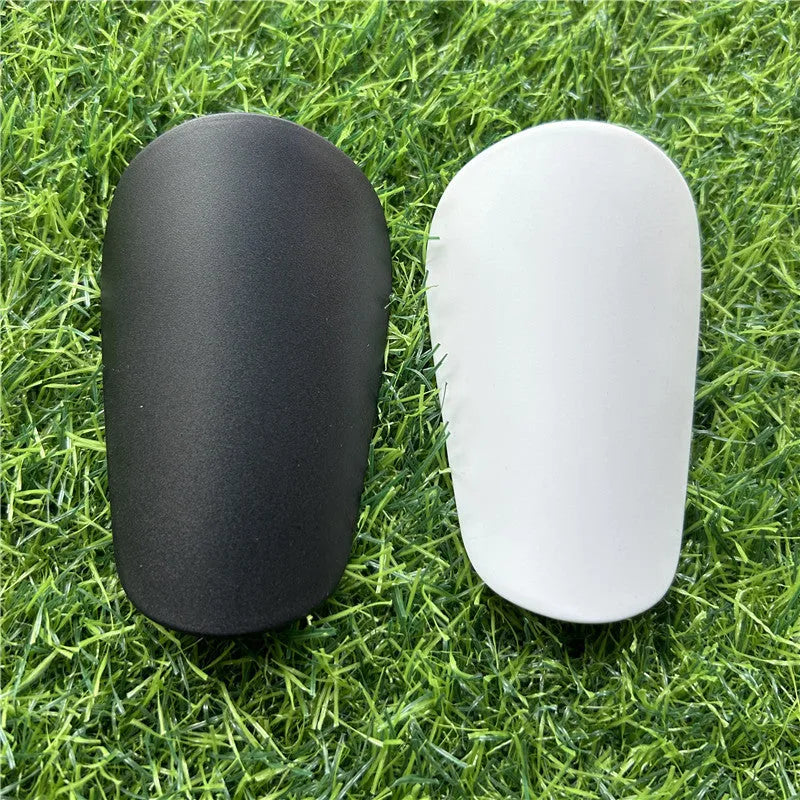 Extra small plastic football shin guards in black and white colours for youth players