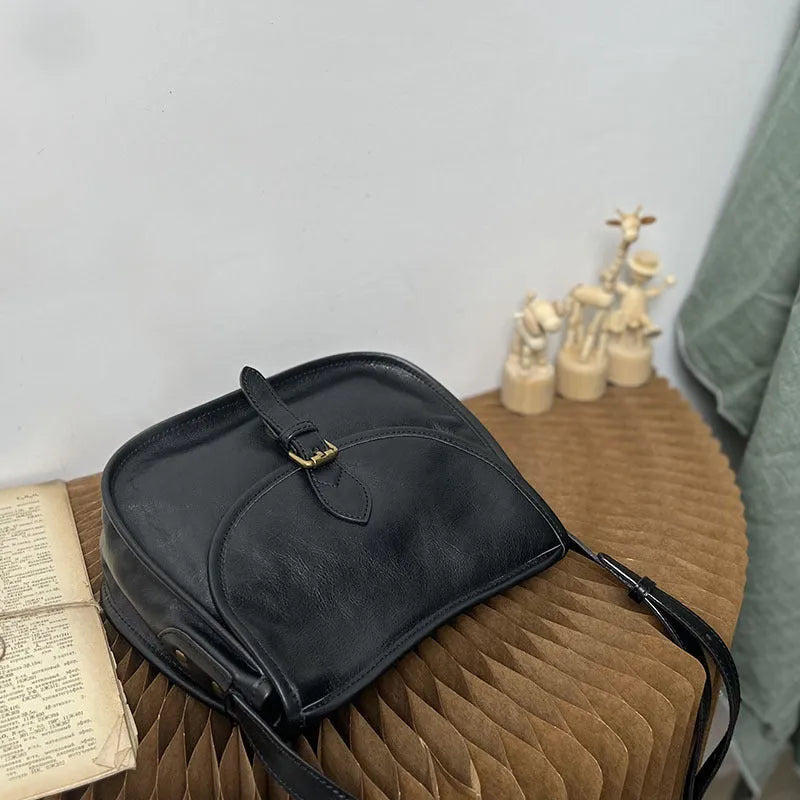Genuine leather messenger bag in brown colour showing flap closure and textured cowhide material