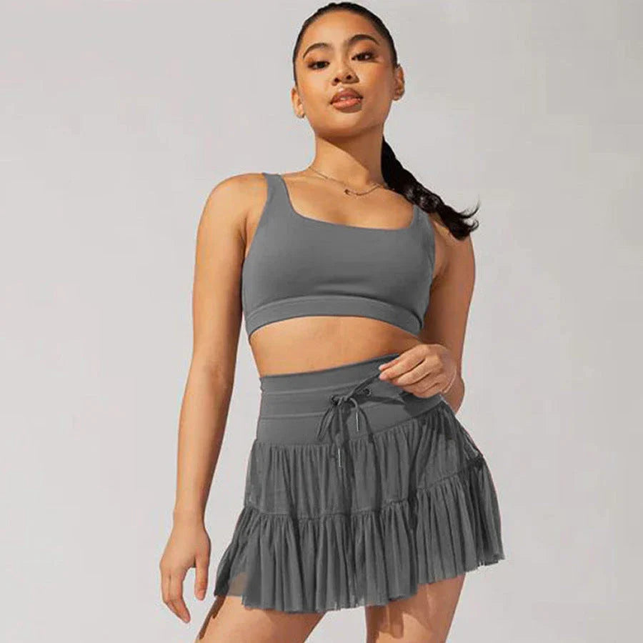 Stylish high-waist pleated mini skirt with lace-up design and built-in anti-exposure safety shorts, available in a variety of vibrant colors.