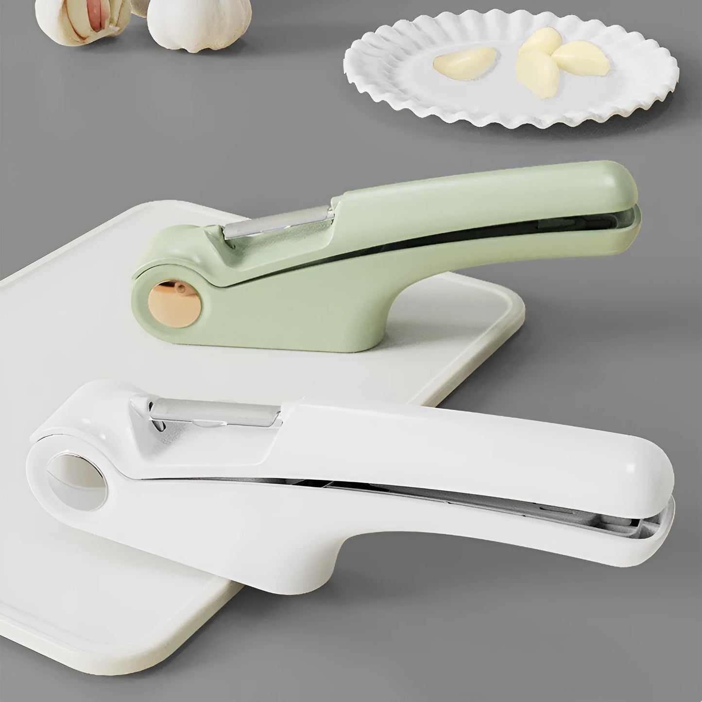 White manual garlic press with stainless steel mechanism on wooden kitchen surface