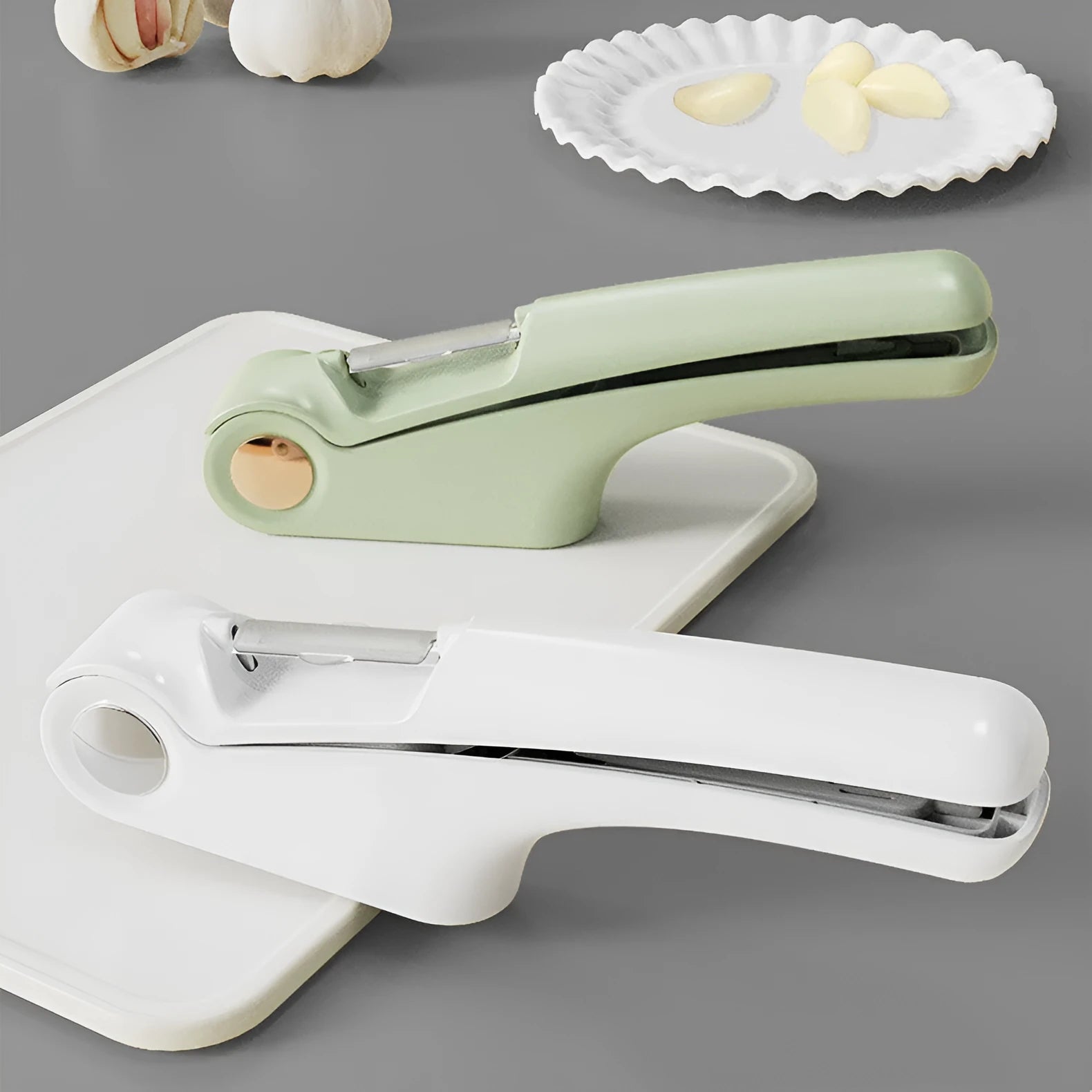 White manual garlic press with stainless steel mechanism on wooden kitchen surface