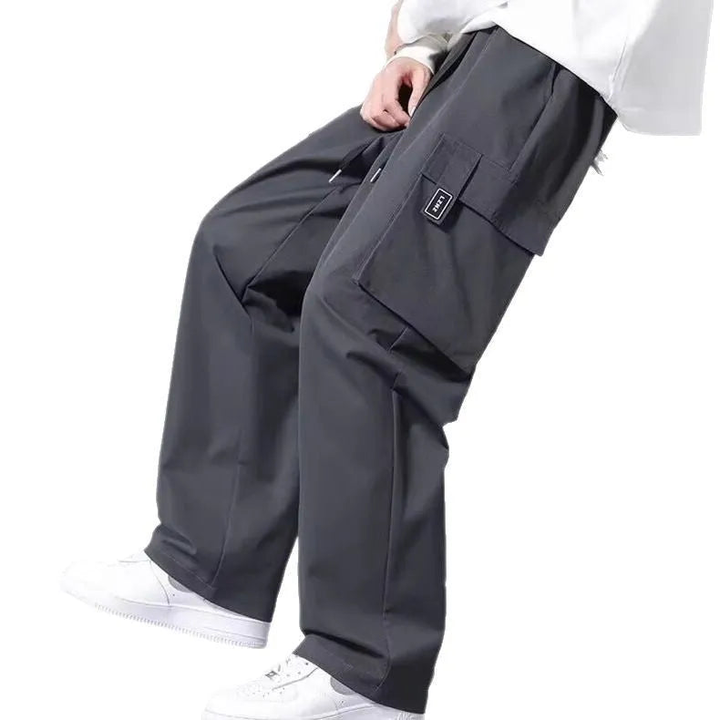 Boys in straight leg cargo trousers with drawstring waist and large side pockets, shown in Army Green.
