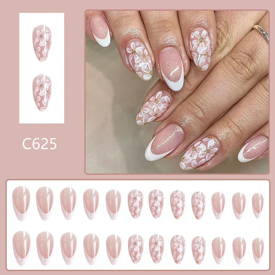 Short glossy almond artificial French nails with glitter flower design on white tips