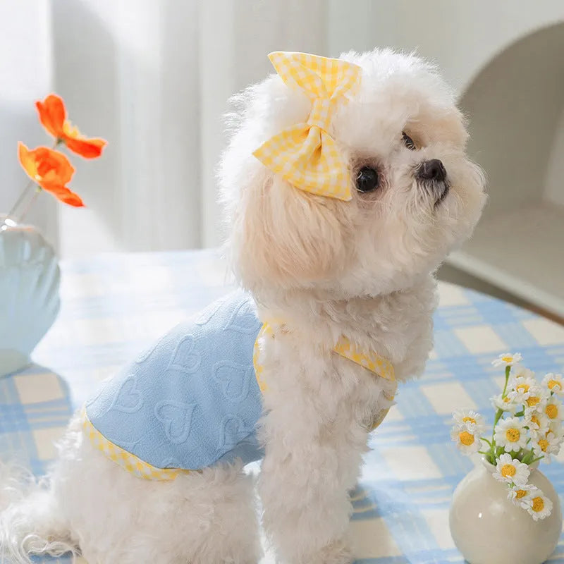 Small dog wearing blue elastic vest with suspenders and bow detail, showing stretch fit