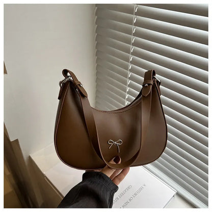 Women's silver dumpling-shaped PU crossbody bag showing front sandwich pocket and single shoulder strap.